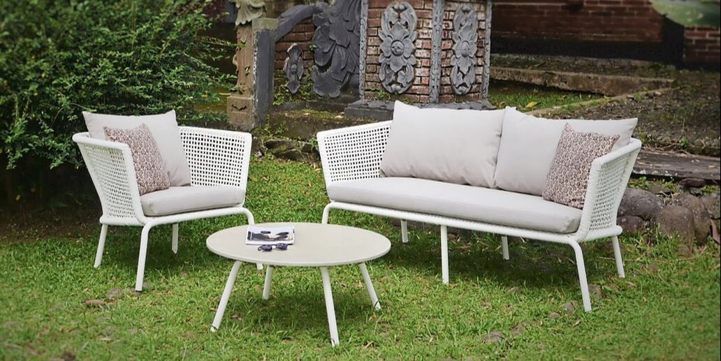 Sofá y sillón de jardín con mesa de cafe redonda con tablero de piedra en jardin de benahavis