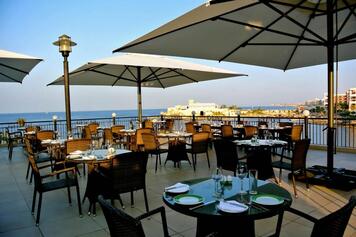 Sombrillas y parasoles en restaurante club de golf Nueva Andalucía con estufas de jardín y terraza una noche de verano andaluz