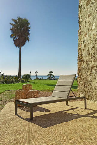 hamaca en Estepona jardín de la costa del sol con alfombra para exteriores y candelabros de fibra natural.