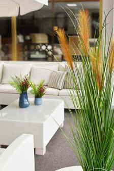 Plantas decorativas en un sofá rinconera de exterior con cojines lavables y totalmente aptos para resistir el clima de la costa mediterránea