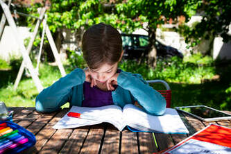 adolescente estudiando en una mesa de jardin en la costa del sol