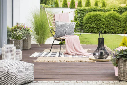 Muebles y maceteros de terraza y jardín fabricados en España en una tarima de madera para villa andaluza 