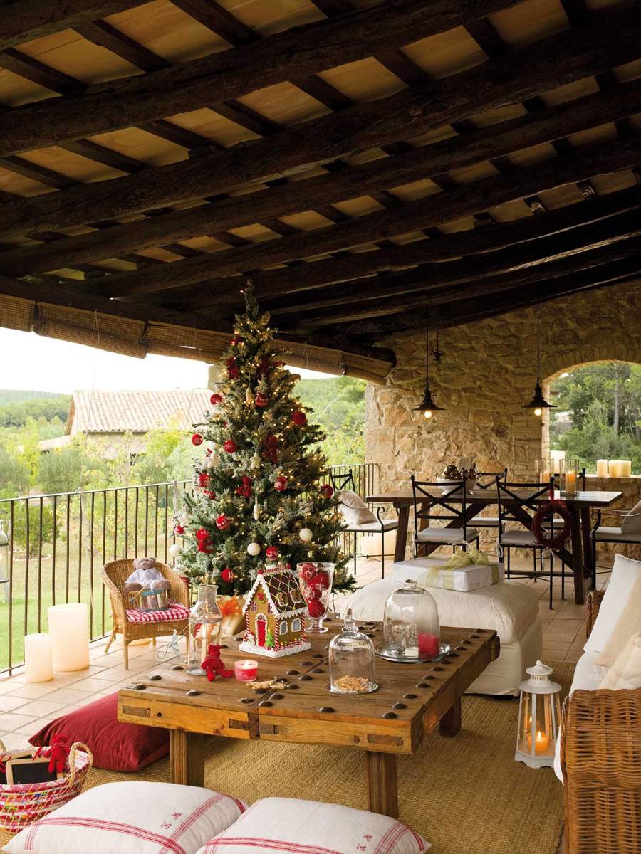 porche d emadera con mueble de jardin y mesa de hierro y sillones de juego con un gran arbol de navidad